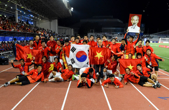 베트남 선수들이 박 감독과 함께 우승 기념사진을 촬영하고 있는 모습. 베트남 국기와 태극기를 함께 든 모습이 인상적이다. 마닐라 AFP 연합뉴스