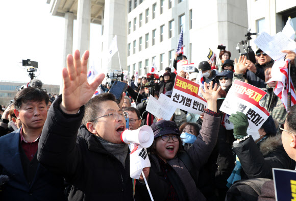 자유한국당 황교안 대표가 16일 서울 여의도 국회에서 열린 ‘공수처법 선거법 날치기 저지 규탄대회’ 참가자들과 함께 시위를 벌이고 있다. 이들은 본청 무단 진입을 시도하다 경찰에 막혀 입구에서 집회를 열었다. 2019.12.16 연합뉴스