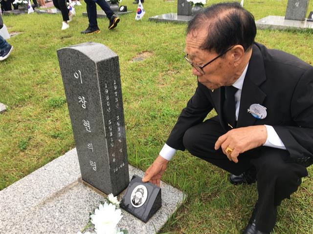 1980년 5월 19일 만 7살 나이에 실종된 이창현군의 아버지 이귀복씨가 지난해 5월 18일 광주 국립5·18민주묘지에서 아들 묘비에 남겨진 사진을 쓰다듬고 있다. 연합뉴스