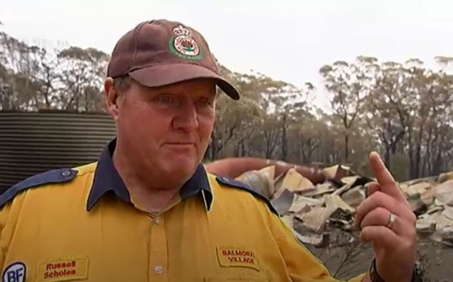 호주 의용소방대원 러셀 스콜스가 22일(현지시간) 아침 불에 타서 모든 것이 쓰러진 자신의 집을 찾아 가리키며 화재 진압 상황을 얘기하고 있다. ABC 동영상 캡처