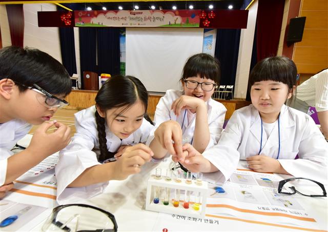 LG화학이 제공하는 ‘재미있는 화학놀이터’ 프로그램에 참여한 초등학생들이 실험도구들을 만지면서 살펴보고 있다. LG화학 제공