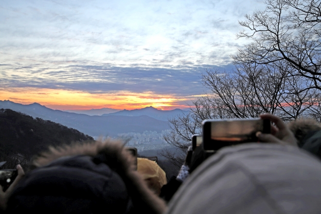 2019년 1월 1일 서울 도봉구 도봉산 천축사에서 바라본 일출 광경을 시민들이 휴대전화 카메라로 찍고 있다. 2019.12.27. 도봉구 제공