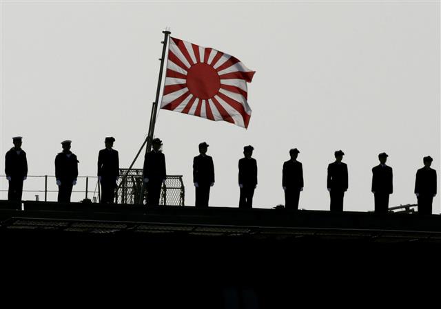 2015년 10월 18일 일본 가나가와현에서 아베 신조 총리가 해상자위대를 사열할 당시 구축함에 도열한 병사들 머리 위로 커다란 욱일기가 휘날리고 있다. EPA 연합뉴스