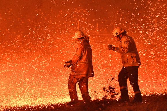 2020년을 맞은 지구촌에는 새로운 10년에 대한 기대와 우려가 공존했다. 호주 산불이 계속되는 가운데 지난달 31일 소방관들이 뉴사우스웨스트주 나우라 인근에서 화마와 싸우고 있다.  뉴사우스웨스트 AFP 연합뉴스
