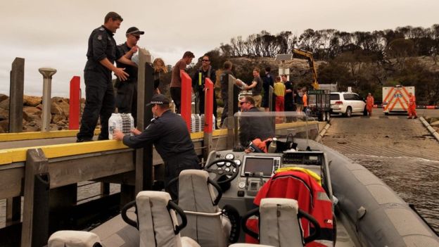 산불로 극심한 피해를 입은 호주 빅토리아주 말라쿠타에 경찰 보트가 당도해 식수 등을 부리고 있다. 빅토리아주 경찰 제공 영국 BBC 홈페이지 캡처