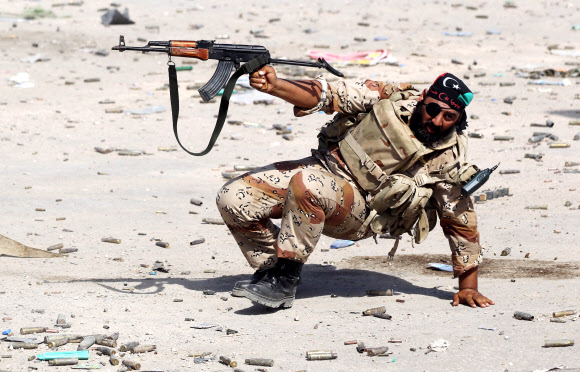 지난해 10월 15일 한 리비아 반군 병사가 시트테 시를 해방카기위한 전투에서 총을 쏘고 있다. 시르테 EPA 연합뉴스