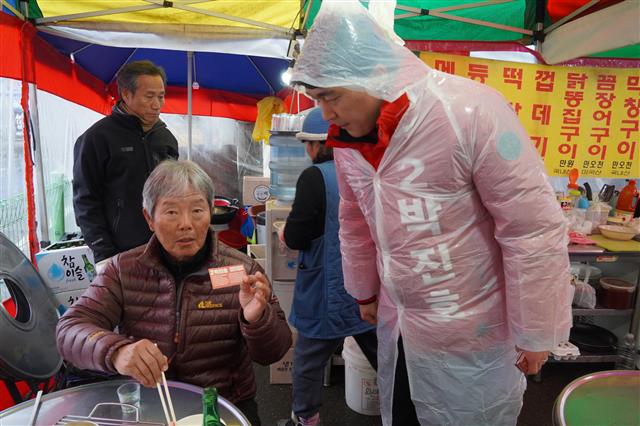 박 예비후보가 김포5일장 포장마차에서 점심을 먹는 시민에게 인사하고 있다.