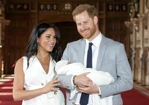 해리 영국 왕자와 메건 마클 왕자비 부부가 지난해 5월 8일(현지시간) 윈저궁에서 아들 아치를 언론에 공개하며 활짝 웃고 있다. AP 자료사진 연합뉴스
