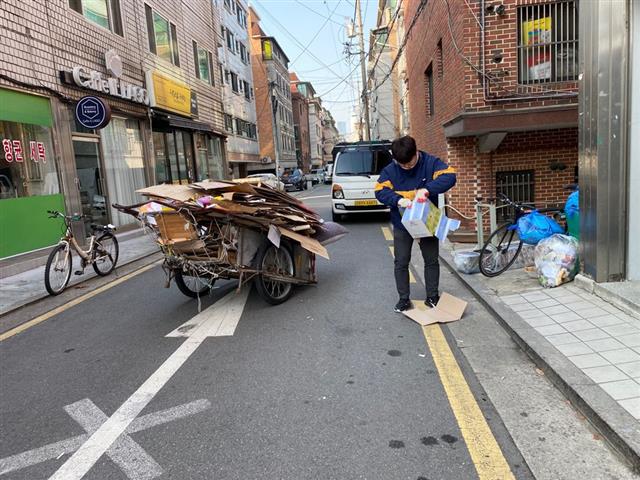 최영권 기자가 박스에 있는 테이프를 떼고 박스를 분해하는 모습. 좁은 골목길에서 리어카를 차량 통행에 방해되지 않도록 주차하는 게 관건이었다.