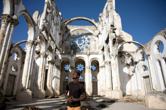 Paul Christandro poses for a picture inside of Notre Dame de l‘Assomption Cathedral (Our Lady of the Assumption), destroyed in 2010 earthquake, in Port-au-Prince