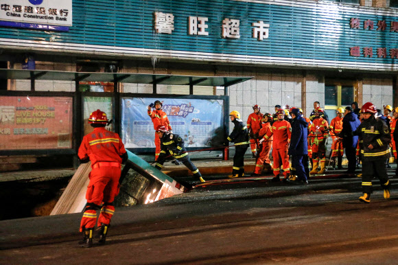 중국 칭하이성 시닝의 구호요원들이 13일 싱크홀에 처박힌 버스를 중장비를 이용해 끌어 올릴 준비를 하고 있다. 시닝 AFP 연합뉴스 