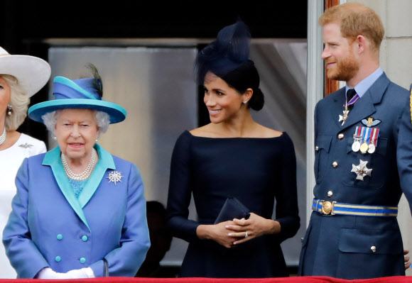 엘리자베스 2세(왼쪽부터) 영국 여왕, 메건 마틀 왕손비, 해리 왕손이 2018년 7월 10일 런던 버킹엄궁 발코니에서 영국 왕립 공군 창설 100주년을 기념한 에어쇼를 지켜보고 있다. AFP 자료사진 연합뉴스