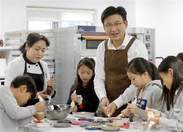 박성수(가운데) 서울 송파구청장이 지난해 12월 31일 송파구 잠실동 ‘잠실청소년센터’ 4층에 위치한 실습실에서 청소년들과 함께 ‘쇼콜라티에’ 직업체험 프로그램에 직접 참여해 보고 있다. 송파구 제공