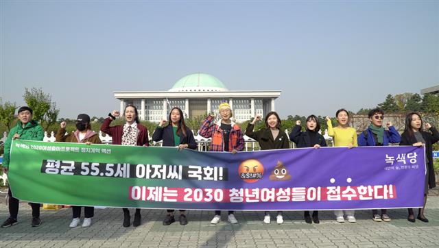 녹색당 당원들이 지난 10일 국회 앞에서 ‘평균 55.5세 아저씨 국회! 이제는 2030 청년여성들이 접수한다’고 적힌 현수막을 들고 캠페인을 진행하고 있다. 녹색당 제공
