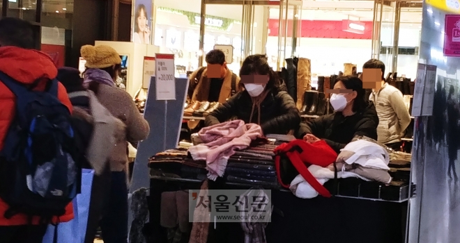 서울역에서 마스크 쓴 채 근무하는 의류매장 직원