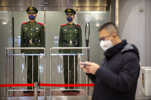 중국 베이징 서우두국제공항에서 지난 23일 공안들이 마스크를 쓰고 경비 근무 중이다. 2020.1.29  AP 연합뉴스