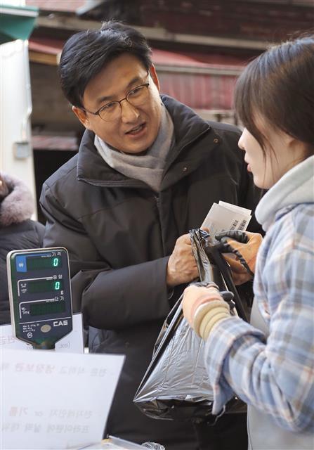 박성수(왼쪽) 송파구청장이 지난 22일 서울 송파구 잠실동 새마을전통시장에서 명절 음식을 구입하며 상인과 얘기하고 있다. 송파구 제공