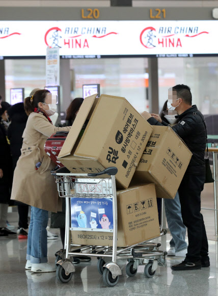 3일 오후 인천국제공항 1터미널에서 중국인 여행객들이 마스크 박스가 실린 카트를 밀고 탑승수속대로 향하고 있다.  2020.2.3  연합뉴스