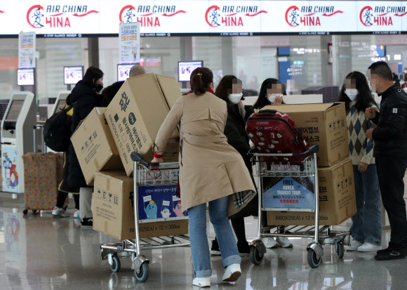 3일 오후 인천국제공항 1터미널에서 중국인 여행객들이 마스크 박스가 실린 카트를 밀고 탑승수속대로 향하고 있다.  2020.2.3  연합뉴스