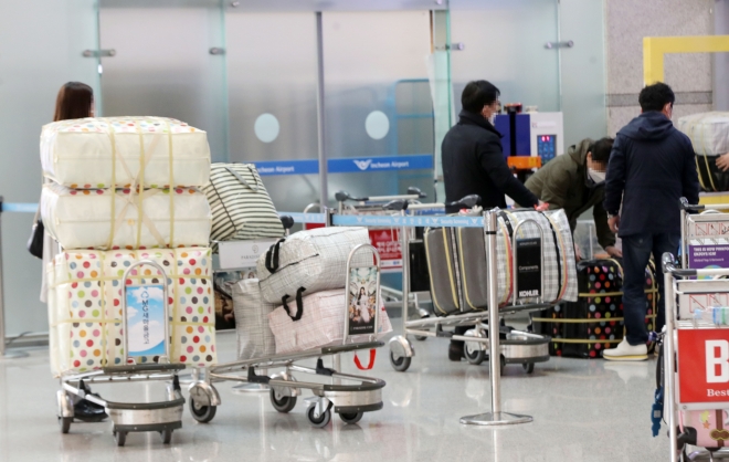 4일 오후 인천국제공항에서 공항 이용객들이 마스크가 든 수레를 운반하고 있다. 2020.2.4 연합뉴스
