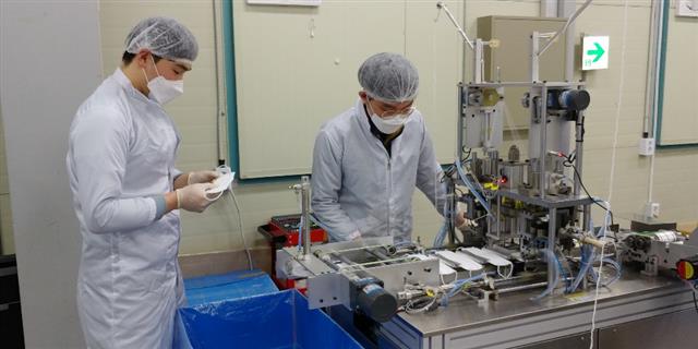 대전 대덕테크노밸리 마스크 제조업체 레스텍 직원들이 9일 공장 안 기계 앞에서 마스크 생산과정을 지켜보며 불량품 등이 있는지 점검하고 있다.