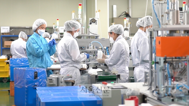 신종 코로나바이러스 감염증 확산으로 마스크 수요가 급증한 가운데, 지난 7일 오후 경기도 안성시에 있는 마스크 제조업체 이앤더블유(E&W)에서 직원들이 마스크를 만들고 있다.