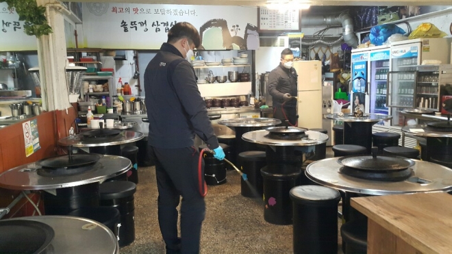 구청 담당자들이 지난 10일 서울 중랑구 면목동 동부시장에 위치한 식당 내부를 살균 소독하고 있다.  중랑구 제공 