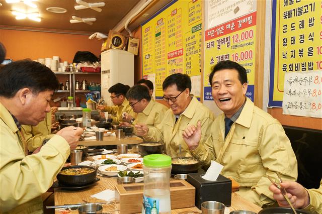 13일 코로나19(신종 코로나바이러스 감염증) 우려로 손님의 발길이 뚝 끊긴 돈암제일시장의 한 콩나물국밥집을 찾은 이승로(오른쪽 첫 번째) 성북구청장이 직원들과 함께 식사를 하고 있다. 성북구 제공