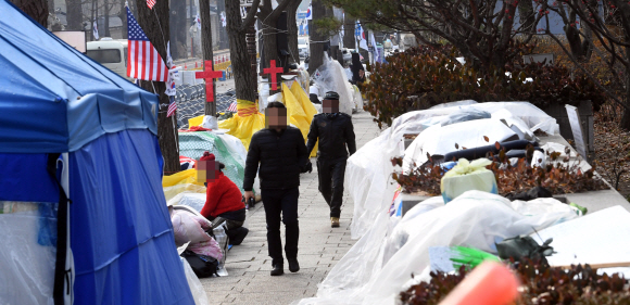 서울시가 13일 서울 종로구 효자동 청와대 앞에서 농성 중인 ‘문재인하야범국민투쟁본부’ 등 9개 단체의 불법 천막 13개와 적치물을 철거하는 행정대집행을 진행했다. 사진은 지난해 12월 22일 문재인하야범국민투쟁본부가 설치한 불법 건축물이 인도 통행에 불편을 야기하고 있는 모습. 정연호 기자 tpgod@seoul.co.kr