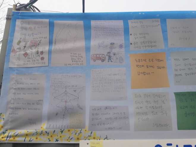 15일 충북 진천군 국가공무원인재개발원과 약 400m 떨어져 있는 한국교육과정평가원 주차장 한 켠에 마련된 ‘우한 교민에게 드리는 글’ 게시판 위에 중국 우한에서 온 교민들의 손편지가 인쇄된 현수막이 걸려 있는 모습. 진천 오세진 기자 5sjin@seoul.co.kr