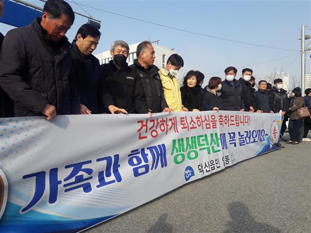 지난 15일 충북 진천군 덕산읍 주민들이 진천군 국가공무원인재개발원 앞에 모여 중국 우한 교민들의 퇴소를 축하하는 내용의 현수막을 들고 있는 모습.  진천 오세진 기자