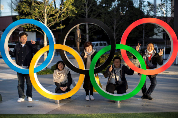 도쿄올림픽 심볼 앞에서 포즈 취하는 일본인들