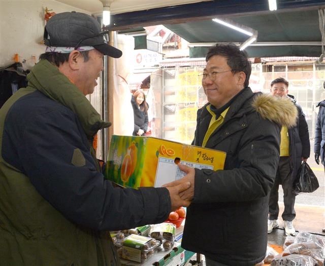 서양호(오른쪽) 서울 중구청장이 지난 17일 중구 신당동 약수시장의 한 과일가게에서 한라봉 한 박스를 구매하고 있다. 중구 제공