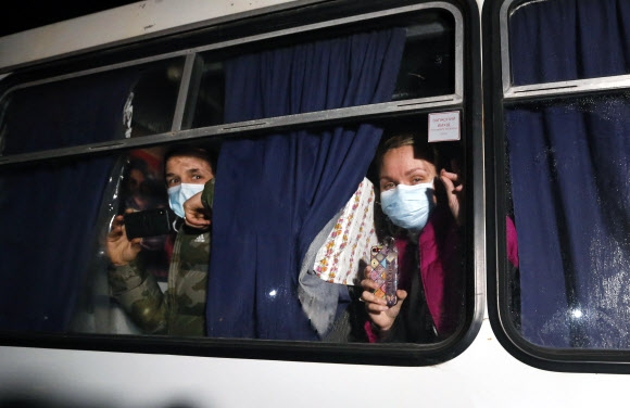 중국 우한을 빠져나와 2주 동안 격리 생활을 하기 위해 버스에 올랐던 승객들이 버스 창문을 통해 바깥 상황을 걱정스럽게 지켜보고 있다. 노비 사르자니 AP 연합뉴스 
