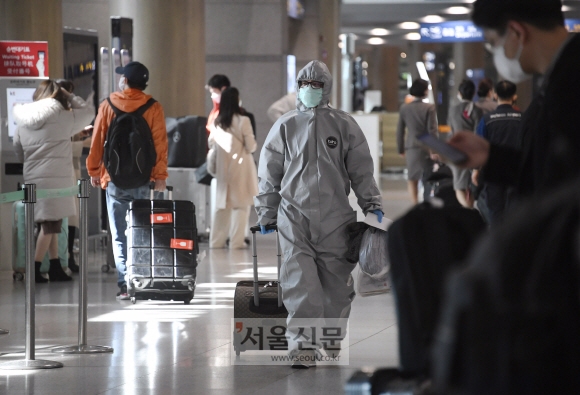 24일 인천공항에 방역복을 입고 입국한 중국유학생이 공항을 빠져나가고 있다. 2020. 2.24. 오장환 기자 5zzang@seoul.co.kr