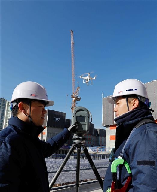 대림산업 직원들이 김포에 건설 중인 ‘e편한세상 김포 로얄하임’ 현장에서 3D 스캐너와 드론을 활용해 BIM 설계에 필요한 자료를 촬영하고 있다. 대림산업 제공