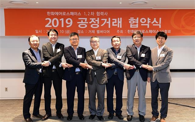 한화에어로스페이스와 1·2차 협력사 임직원들이 지난해 5월 경남 거제 벨버디어에서 열린 공정거래 협약식에서 손을 맞잡고 있다. 한화그룹 제공