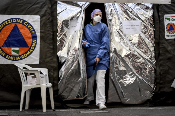 마스크를 낀 의료진이 이탈리아 북부 피아첸자 병원 응급실 밖에 마련된 텐트에서 나오고 있다. 2020.2.28 AP 연합뉴스