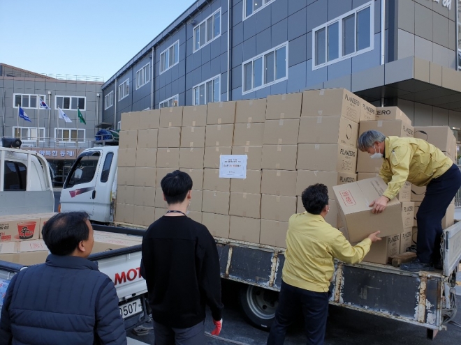 부산 동래구청 직원들이 2일 오후 청사 마당에서 마스크가 담긴 상자를 내리고 있다.<동래구 제공