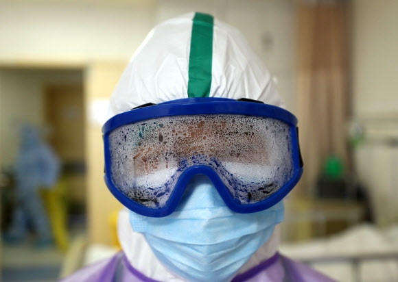 바이러스 진원지인 중국 우한에 설립된 코로나19 전문 병원에서 한 간호사가 습기로 가득 차 뿌옇게 흐려진 보호안경을 쓰고 있다. 우한 EPA 연합뉴스