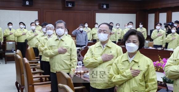 3일 문재인(오른쪽 세 번째) 대통령 주재로 열린 국무회의에서 국무위원들이 전원 민방위복 차림으로 마스크를 쓴 채 국기에 대한 경례를 하고 있다. 도준석 기자 pado@seoul.co.kr