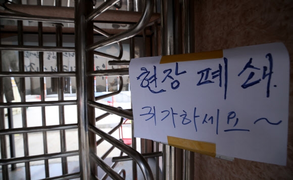 코로나19 확산으로 건설 인력 시장이 꽁꽁 얼어붙었다. 사진은 지난달 28일 서울 영등포구 여의도의 한 복합단지 건설 현장 입구에 붙은 폐쇄 안내문. 이 건설사는 전날 공사 현장 40대 근로자가 코로나19 확진 판정을 받자 건설 현장을 임시 폐쇄했다. 연합뉴스