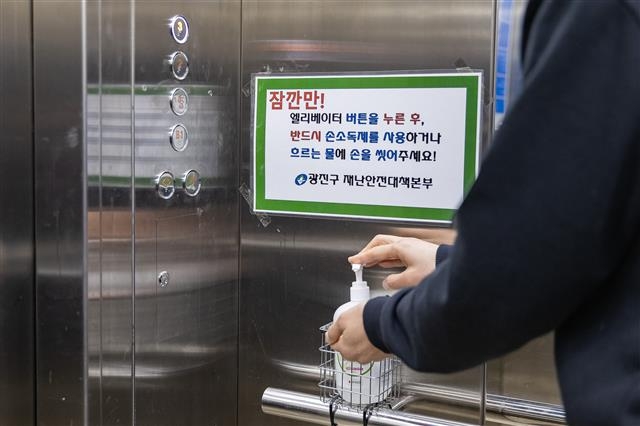 서울 광진구의 한 주민이 아파트 엘리베이터에 설치된 손소독제를 이용해 손을 소독하고 있다. 사진은 본문과 직접 관련 없음. 광진구 제공