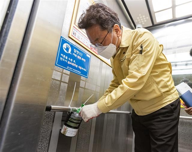 김선갑 서울 광진구청장이 4일 구의동의 한 오피스텔 엘리베이터에 손소독제를 직접 설치하고 있다. 광진구 제공