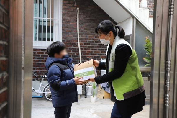 굿네이버스 대구경북본부 직원이 위생 키트와 생필품 키트를 가정에 전달하는 모습.