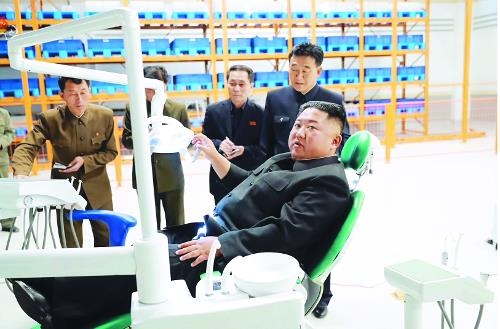 김정은 북한 국무위원장이 지난해 10월 평안북도 묘향산의료기구공장을 방문해 의료기기에 앉은 채 현장 관계자들에게 지시를 내리고 있다.  연합뉴스