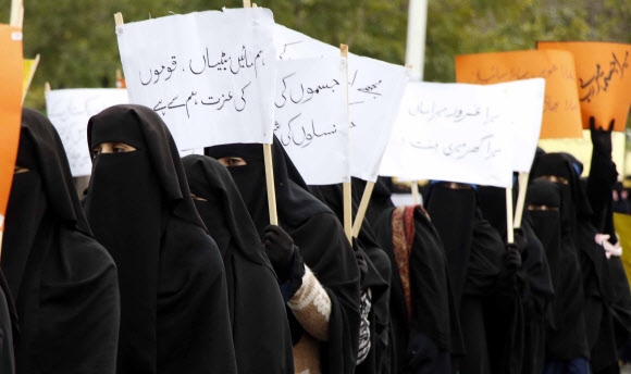 8일(현지시간) 세계 여성의 날을 맞아 파키스탄 이슬라마바드에서 니캅을 쓴 여성들이 팻말을 들고 행진하는 모습. 이슬라마바드(파키스탄) EPA 연합뉴스