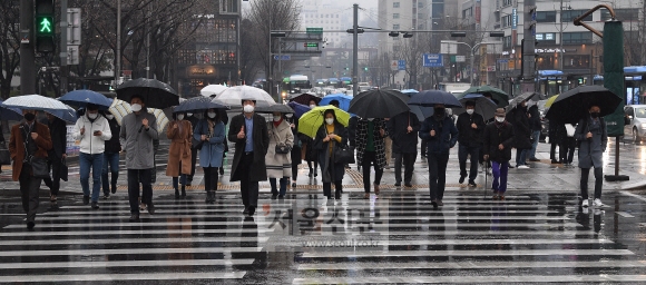 비가 내리는 10일 서울 세종대로사거리에서 마스크와 우산을 쓴 시민들이 출근길 발걸음을 재촉하고 있다. 2020.3.10 오장환 기자 5zzang@seoul.co.kr