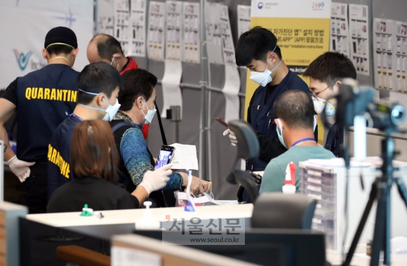한일 두 나라 간 상호 무비자 입국이 중단된 9일 인천국제공항 2터미널에서 일본발 여객기를 타고 도착한 승객들이 검역과 연락처 확인 등의 특별입국절차를 거치고 있다. 2020. 3.9 이종원 선임기자 jongwon@seoul.co.kr