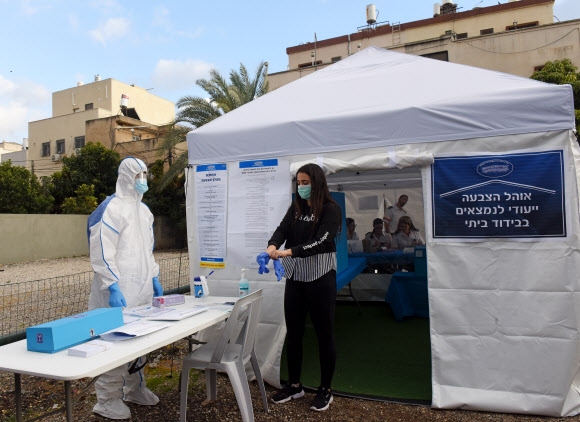 이스라엘 총선을 하루 앞둔 지난 1일(현지시간) 코로나19 관련 자가격리자들을 위해 텔아비브에 마련된 간이 투표소에서 예비점검이 이뤄지고 있다.-텔아비브 UPI 연합뉴스 　